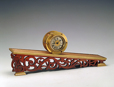 Copper clock with an ornate sloping mount